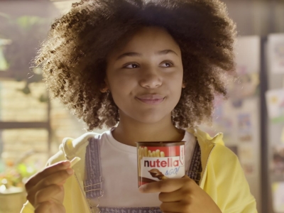 Bambina sorride mentre tiene in mano uno snack Nutella & Go!